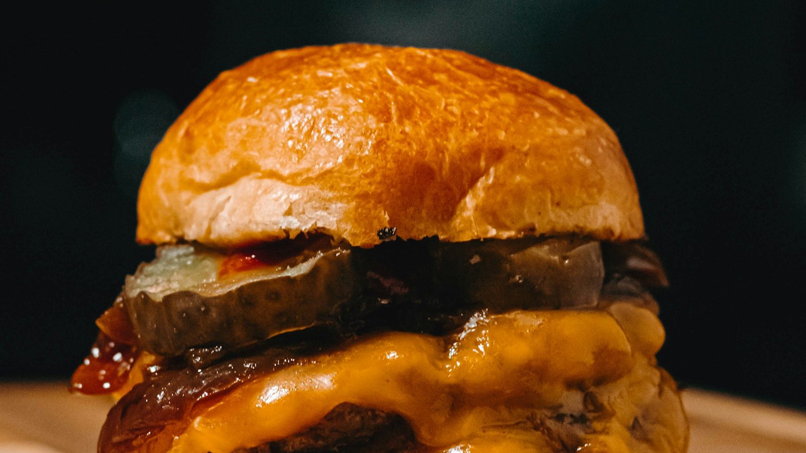 Smash burger com queijo derretido, close dramático